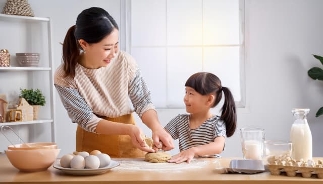 キッチンで楽しそうにクッキーを作っている親子。幸せな家族の時間。