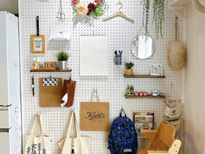 室内の壁面に取り付けられた有孔ボードを活用した収納ディスプレイ。フックや棚を自由にレイアウトでき、見せる収納としてインテリア性と実用性を両立している内装デザイン。