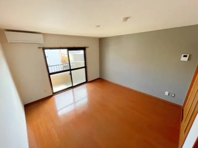 アクセントクロスを取り入れたリビングの内装リフォーム事例。グレーの壁紙とフローリングが調和したシンプルで明るい空間。