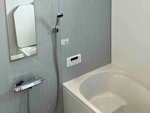 沖縄で行った浴室リフォーム後の施工事例。システムバスの浴槽とシャワーまわりが整い、落ち着いた雰囲気の浴室空間です。