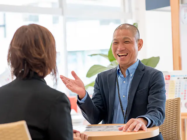 沖縄のリフォーム会社で、担当スタッフがお客様と笑顔で打ち合わせをしている様子