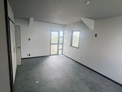 南風原町で中古住宅リフォーム後の洋室（グレー床で統一されたモダンな内装空間）