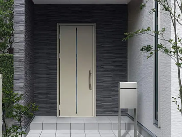 沖縄の住宅で行う玄関ドアリフォームのイメージ。アルミ製玄関ドアと外構ポストが設置された玄関アプローチ